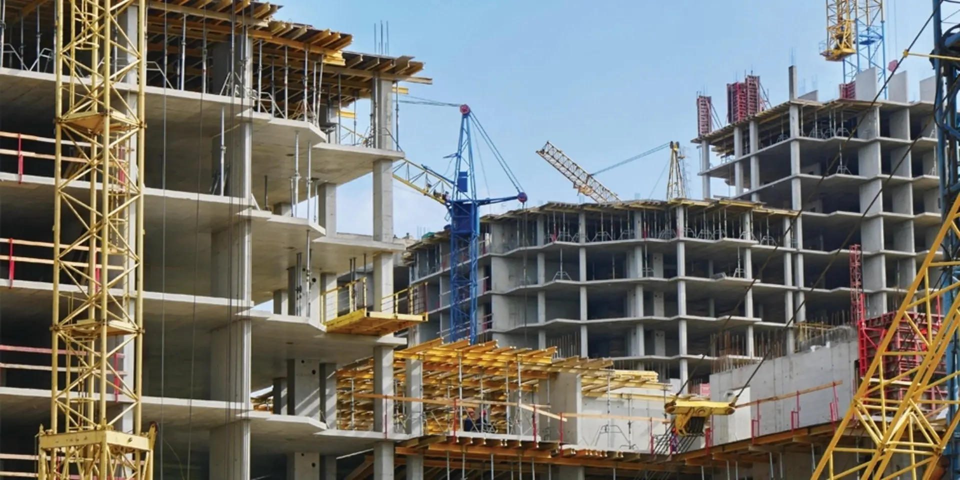 Multi storey concrete buildings under construction with tower cranes