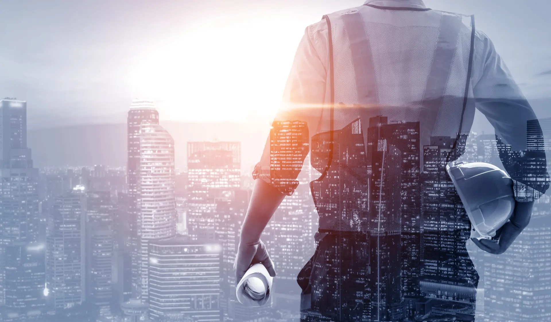 Engineer holding a hard hat and drawings, overlooking a city skyline